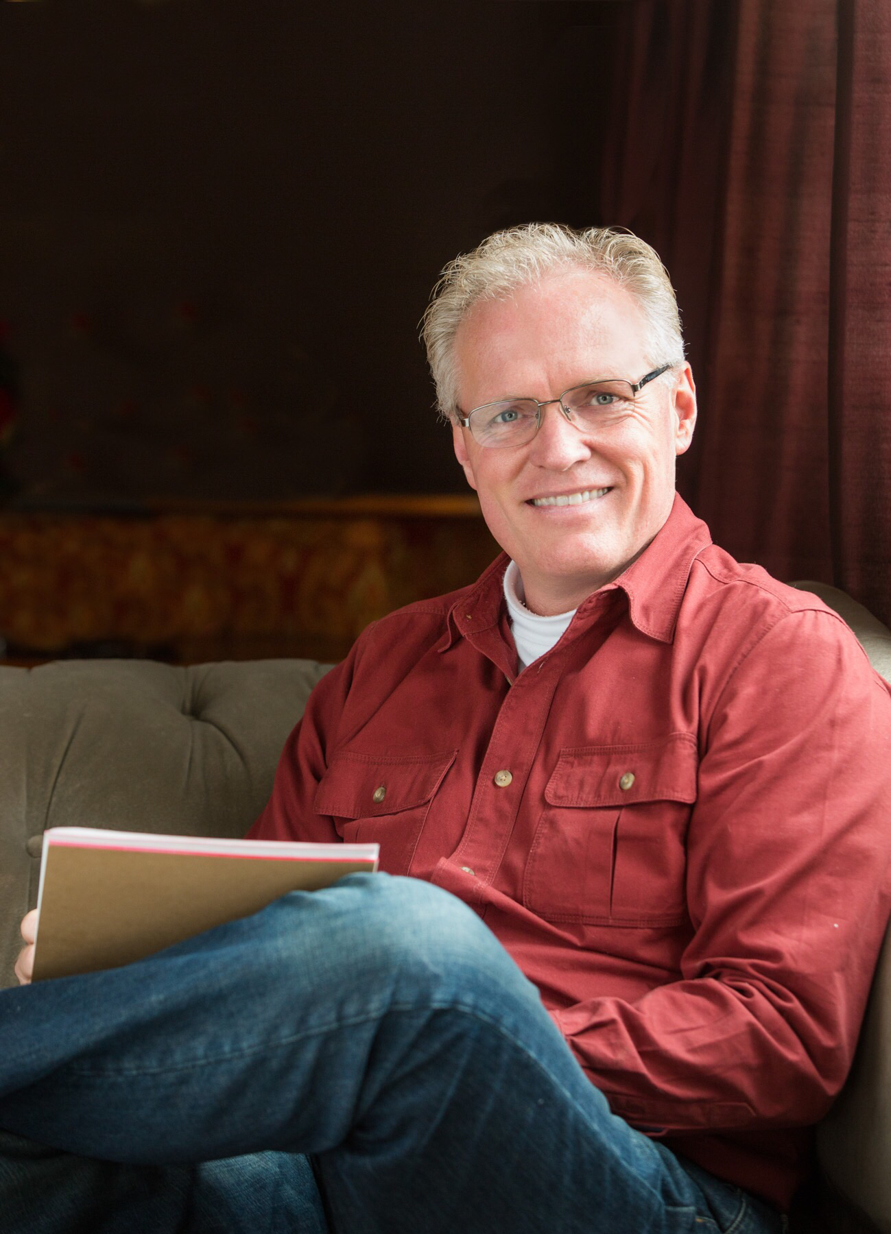 A man sitting on the couch holding a book